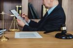 Gavel on wooden table and Lawyer or Judge working with agreement in Courtroom theme, probate law and litigation concept